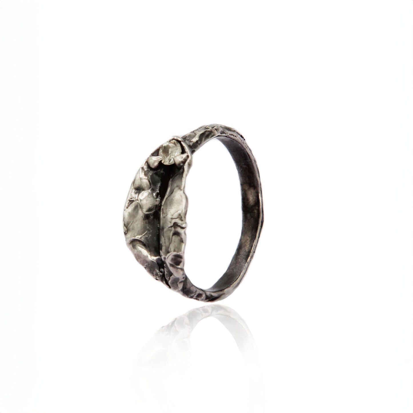 Delilah Impurity Ring in oxidized silver with fluid texture and vulva focal, featuring a white sapphire at the top.