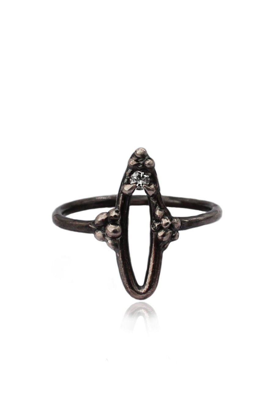Lilith Impurity Ring in dark oxidized silver with an abstract vulva shape and a white sapphire set at the top center