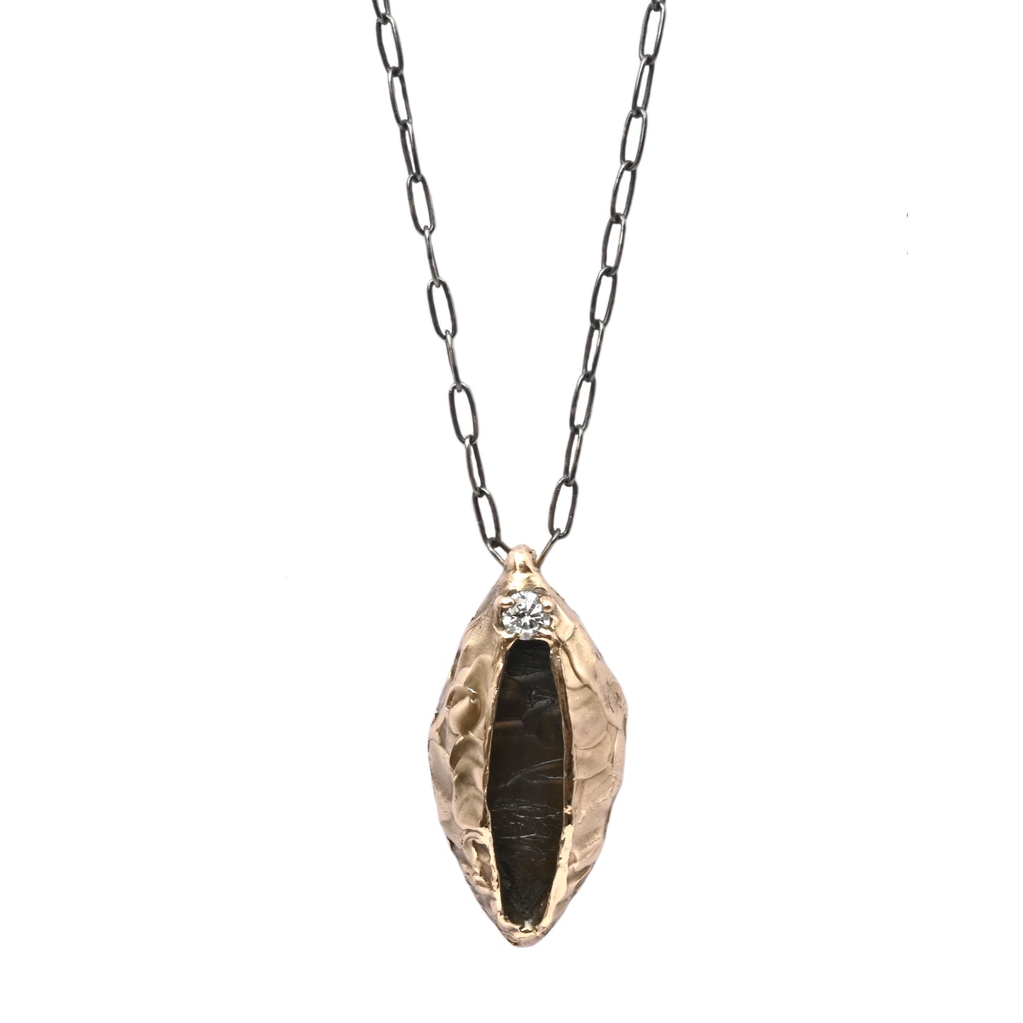 Jael Necklace with a bronze vulva pendant featuring a sparkling cubic zirconia at the top, hanging on an oxidized silver paperclip chain for versatile styling.