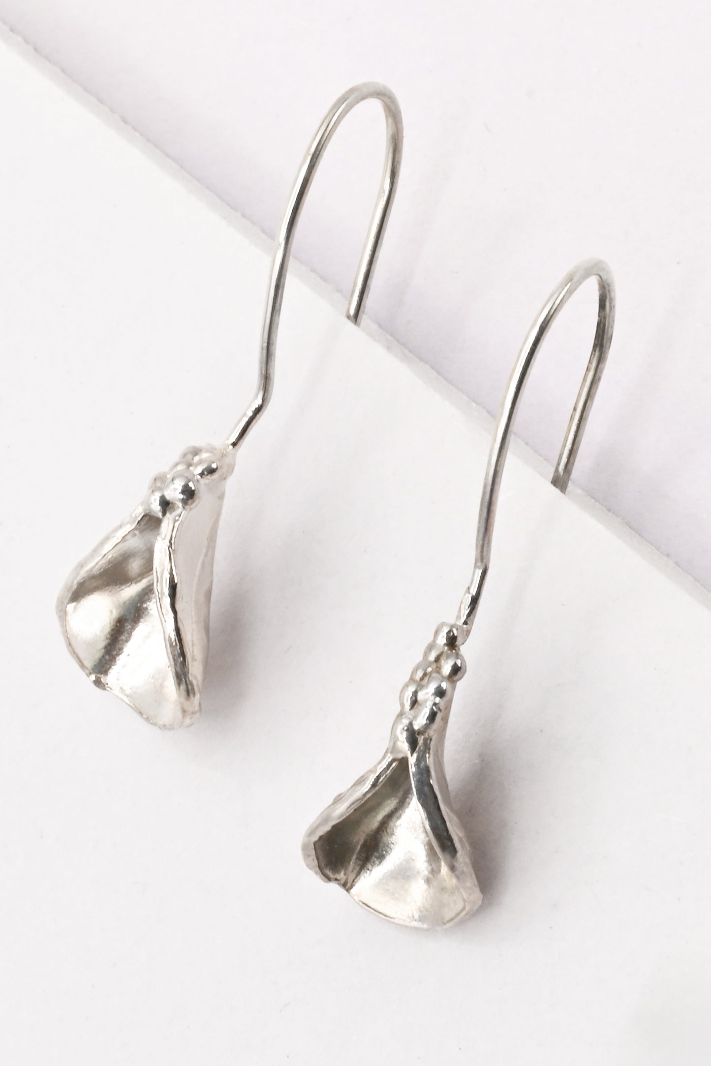 "Persephone" Earrings: Small sterling silver abstract vulva earrings with organic shape and texture created via the lost wax casting method. By Alison Jefferies for Impurity Culture.