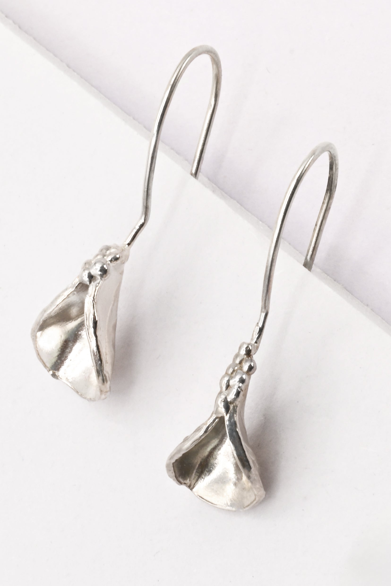 "Persephone" Earrings: Small sterling silver abstract vulva earrings with organic shape and texture created via the lost wax casting method. By Alison Jefferies for Impurity Culture.