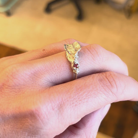 Sterling silver impurity ring with a red sapphire modeled on a white woman's hand, by Impurity Culture jewelry